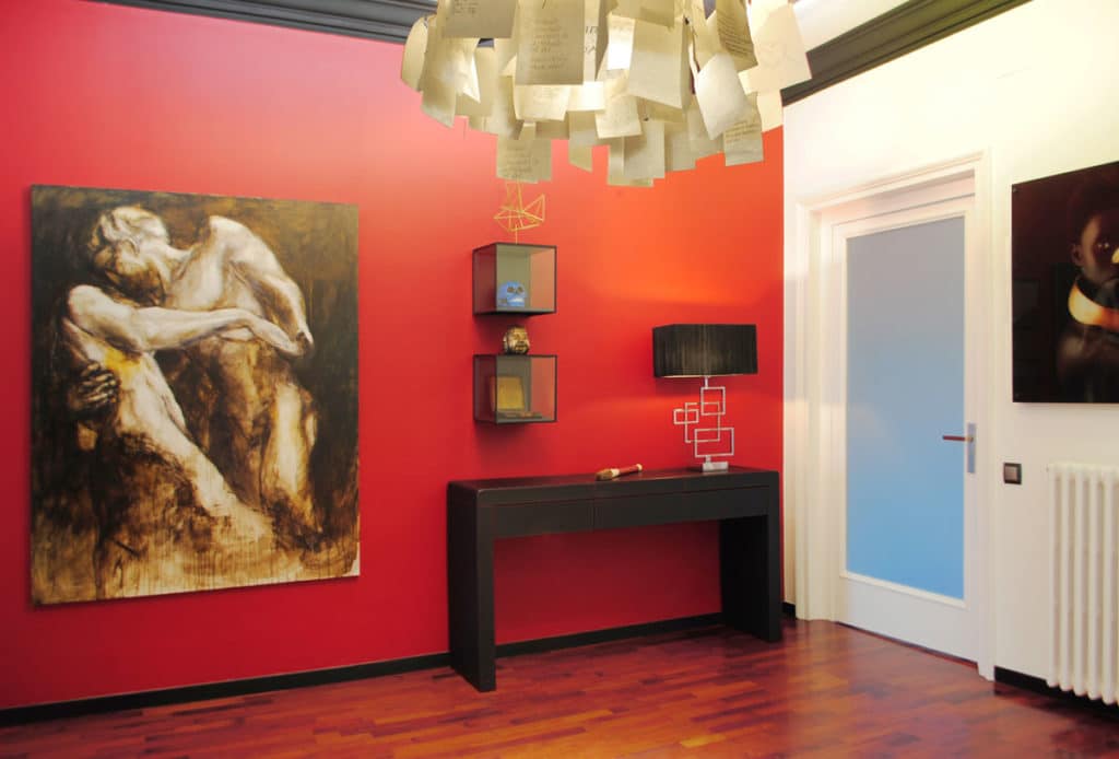 Reforma de interiorismo de un piso en Barcelona diseñado por el estudio de diseño internacional Manuel Torres Design donde se ve la entrada decorada en tonos rojos