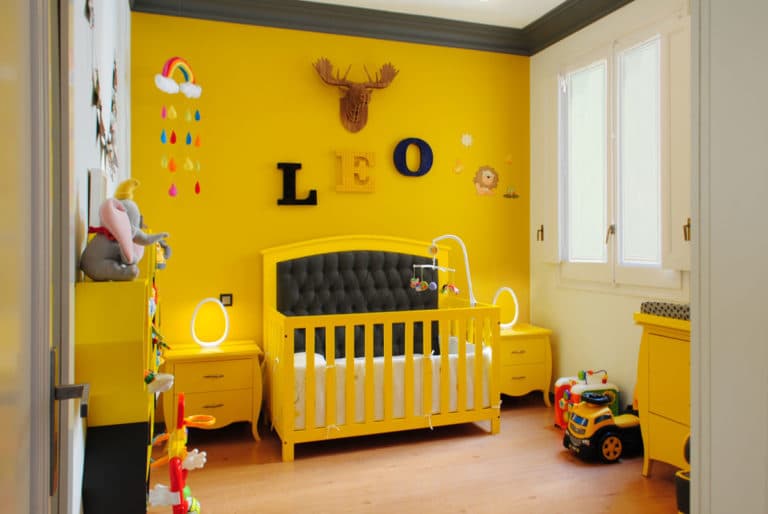 Reforma de interiorismo de un piso en Barcelona diseñado por el estudio de diseño internacional Manuel Torres Design donde se ve un dormitorio infantil decorado en tonos amarillos