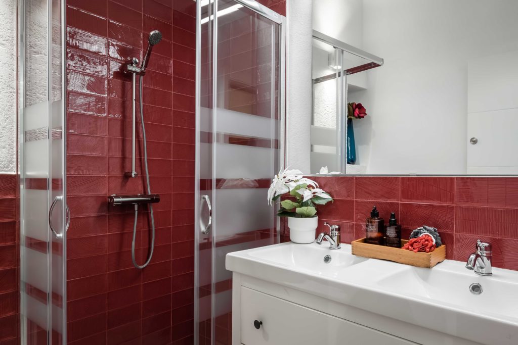 Baño en color rojo y blanco resultado final de la reforma integral y el diseño de interiores de esta vivienda en Barcelona por parte del estudio de diseño internacional Manuel Torres Design